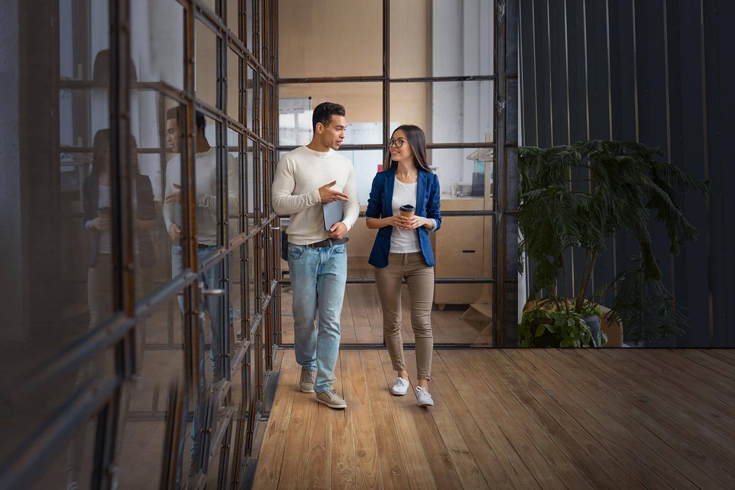 Two young professionals walking down a hall