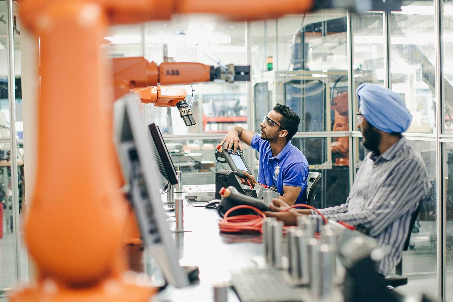 Two workers operating a manufacturing machine